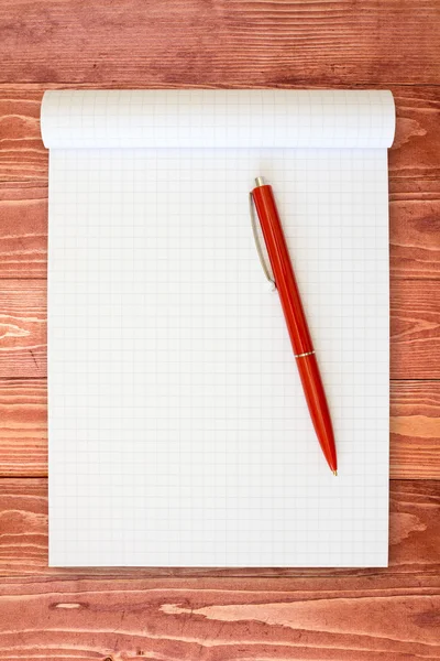 Σημειωματάριο και κόκκινο στυλό στην ξύλινη επιφάνεια — Φωτογραφία Αρχείου