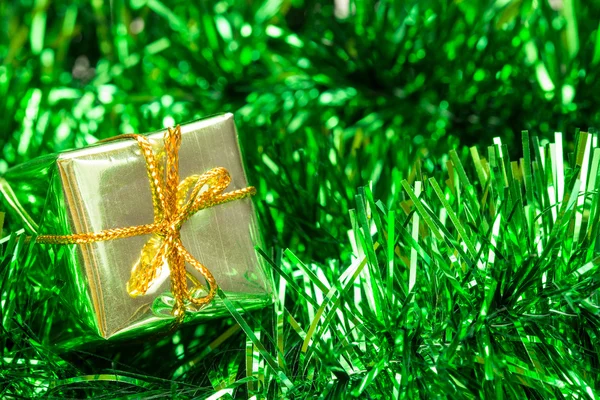 Green tinsel and little gift box — Stock Photo, Image