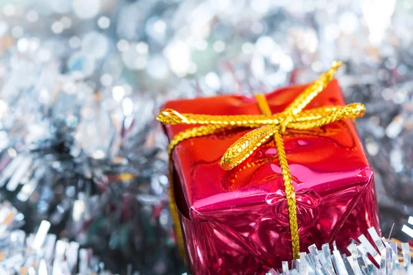 Silver tinsel and red gift box — Stock Photo, Image