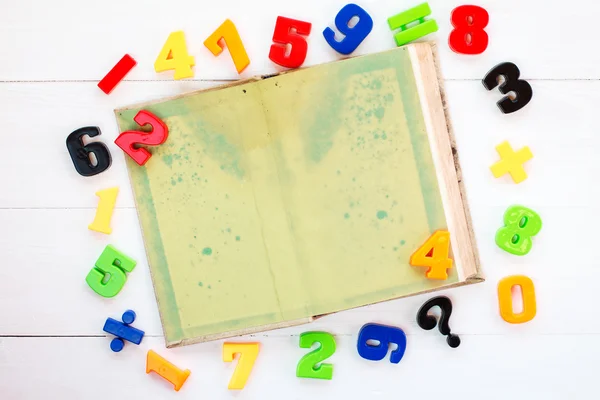 Πολύχρωμα πλαστικά αριθμούς και ανοιχτό βιβλίο — Φωτογραφία Αρχείου