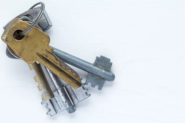 Old keys on white wooden bakground — Stock Photo, Image