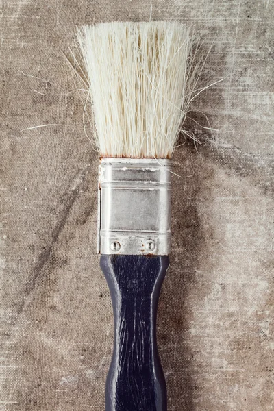 Old paintbrush on a dirty canvas — Stock Photo, Image