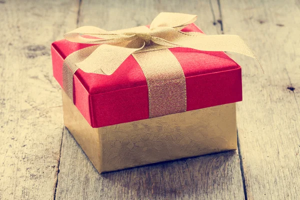 Gift box on old wooden floor — Stock Photo, Image