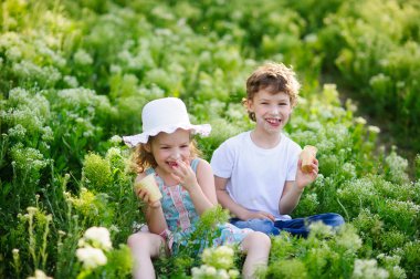 Çocuklar birlikte bahçede oyun, dondurma ve gülümseme yemek