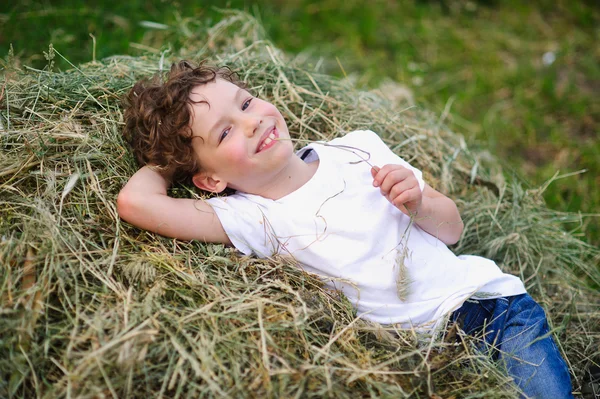 Kind liggend op het hooi — Stockfoto