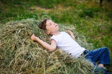 Çocuk saman üzerinde yalan
