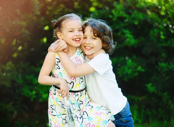 Αγόρι αγκαλιάζει κορίτσι και χαμογελαστός — Φωτογραφία Αρχείου