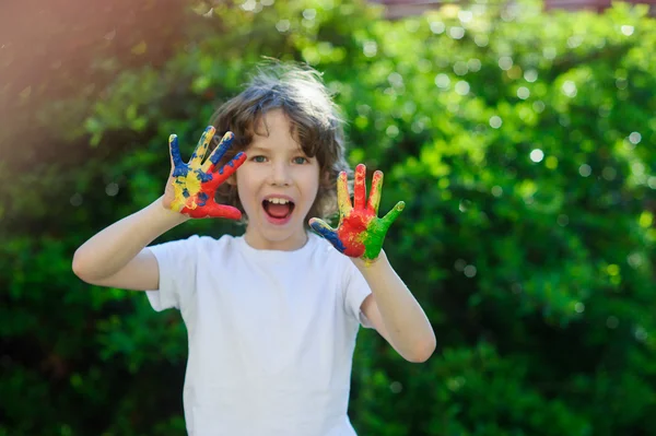 De jongen toont zijn kleurrijke handen — Stockfoto