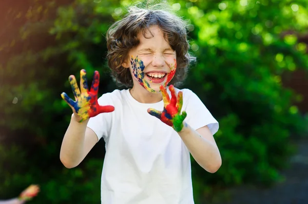 Kind lacht, Gesicht und Hände in der Farbe — Stockfoto