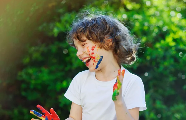 Le visage et les mains de l'enfant dans la peinture — Photo