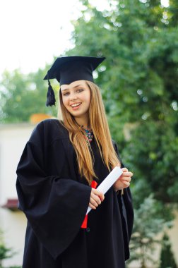 Kap ve elbise içinde neşeli mezunu