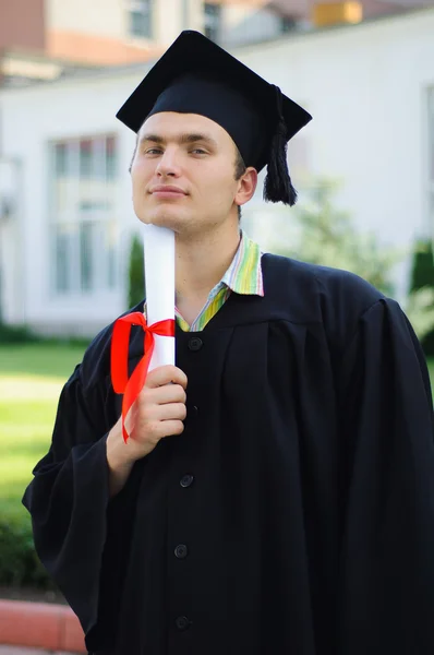 Universitetarkandidat innehar examensbevis bundna med ett rött band — Stockfoto