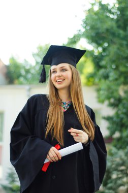 Elinde bir diploma ile mutlu mezunu.