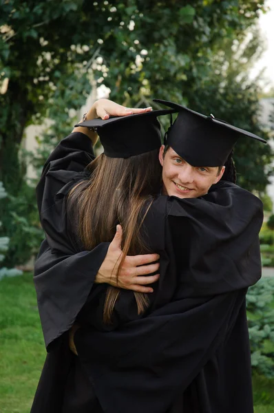 Feliz graduado abraçando seu colega de classe . — Fotografia de Stock