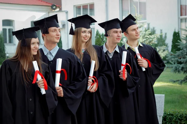 群在他们手中的文凭的大学毕业生 — 图库照片