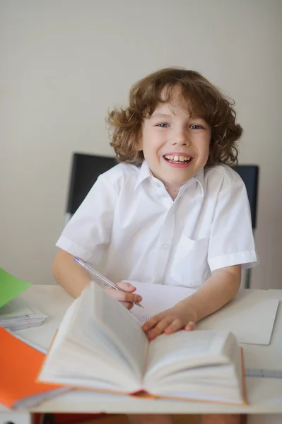 Niño haciendo la tarea sentado en un escritorio de la escuela —  Fotos de Stock