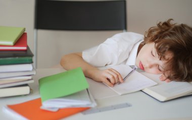 Küçük çocuk ev ödevi yaparken uyuya.