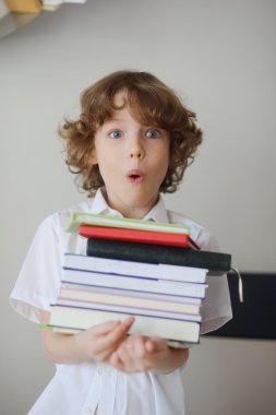 Kitapların bir yığınına holding öğrenci.