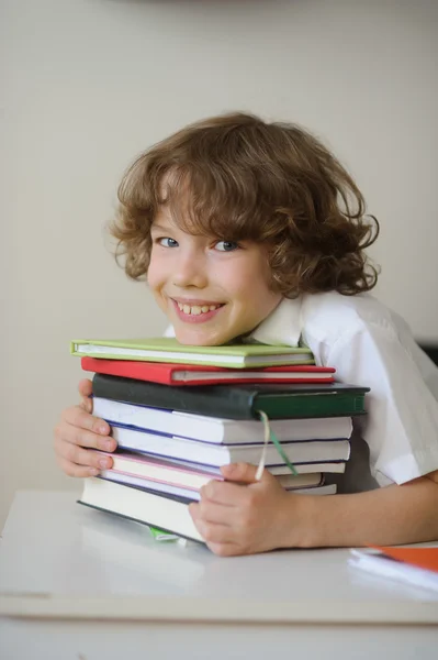 Colegial abrazando una pila de libros —  Fotos de Stock