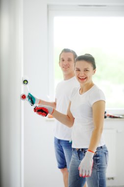 Kız ve adam odanın duvarları boya için