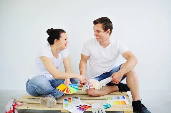 Young people pick up the color to paint the walls — Stock Photo, Image