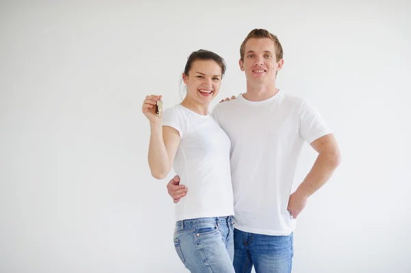 Young couple holding the keys to a new apartment — Stock Photo, Image