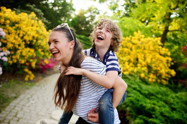 Young woman playing with her son on nature — 图库照片