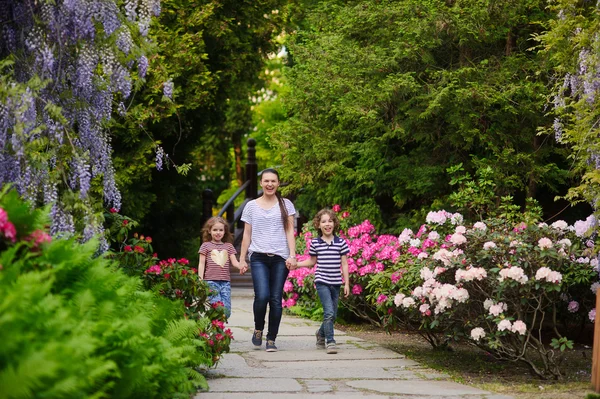 Moeder en twee kinderen lopen in het park — Stockfoto