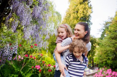 Parkta oynayan iki çocuk ve anneleri