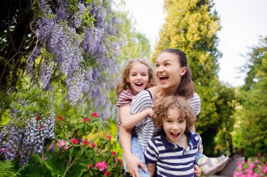 Yemyeşil bir parkta iki çocuk anne