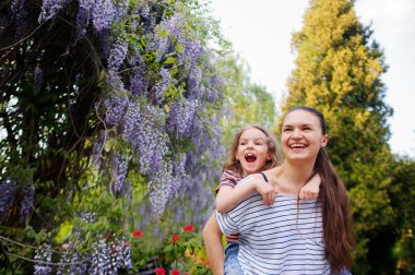 madre e hija caminando en el parque de verano
