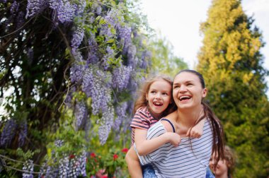 madre e hija caminando en el parque de verano