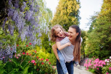 madre e hija caminando en el parque de verano