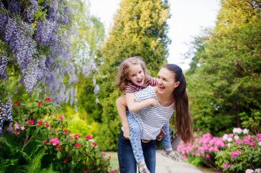 madre e hija caminando en el parque de verano.