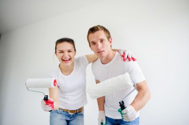 Evde tamir etmeye hazır genç çift, bir odaya bakıyor.