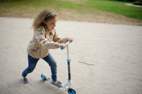 Девушка 7-8 лет ездит на скутере . — стоковое фото