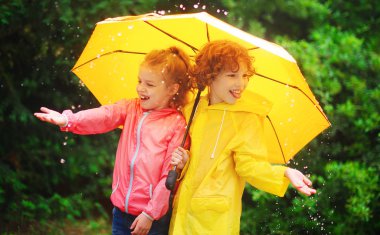 Girl and boy during a rain under one umbrella. clipart