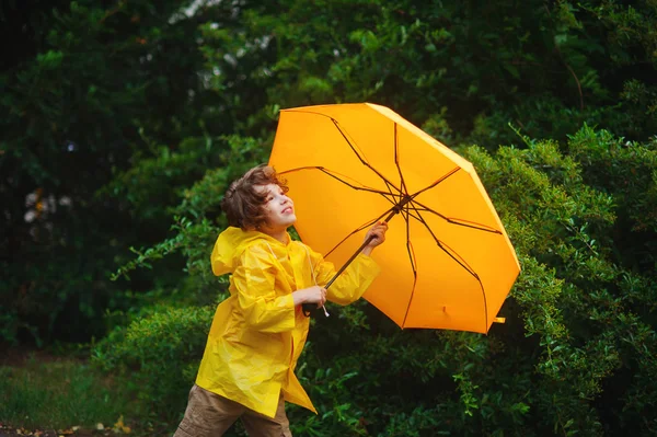 壮大な緑と黄色の傘で 8-9 歳の少年. — ストック写真