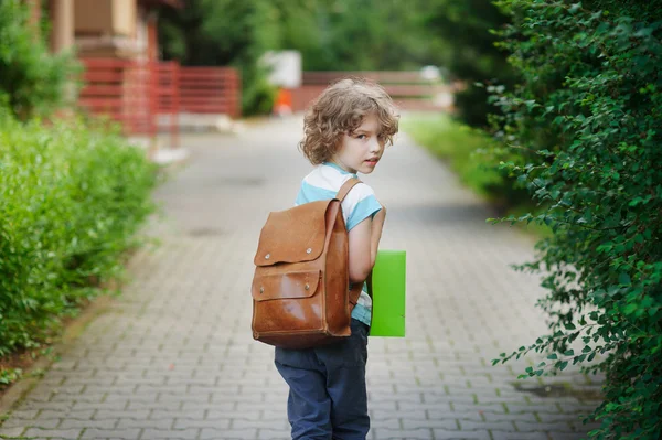 Scholier gaat naar school met een tas achter schouders. — Stockfoto