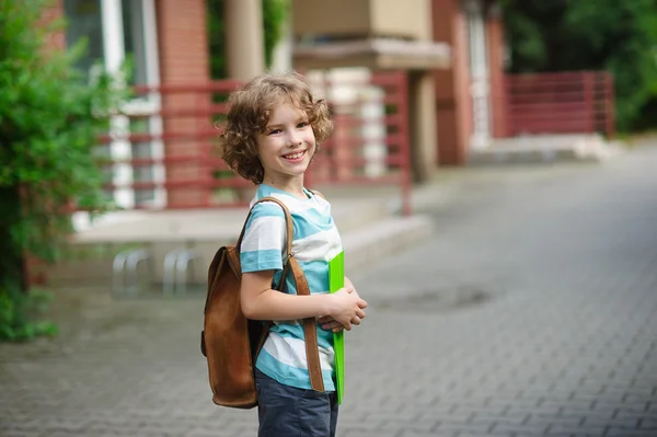 Die Schülerin der Grundschule steht auf dem Schulhof und lächelt. — Stockfoto