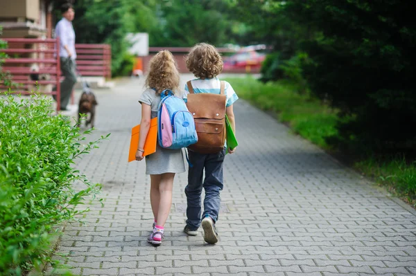 Dos alumnos de primaria van tomados de la mano . — Foto de Stock