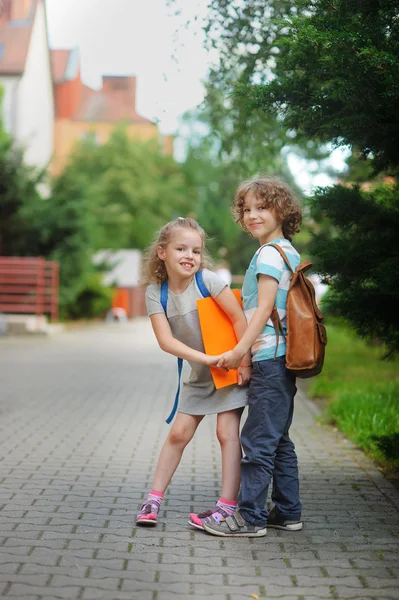 Två elever, pojke och flicka, på väg till skolan. — Stockfoto