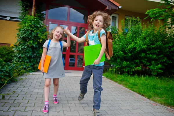 El muchacho y la muchacha van a la escuela habiendo unido las manos . — Foto de Stock