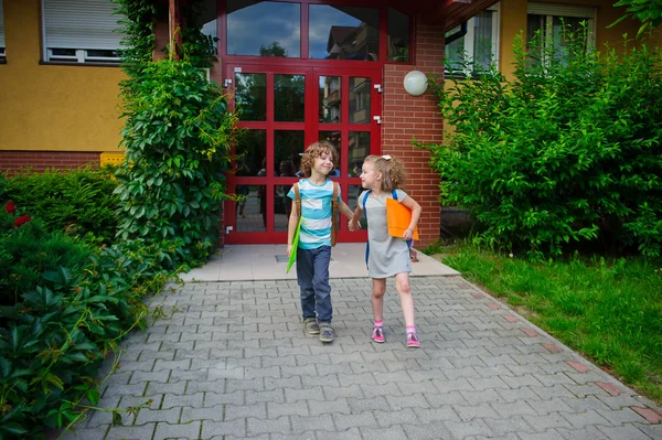 Ragazzo e ragazza vanno a scuola avendo unito le mani . — Foto Stock