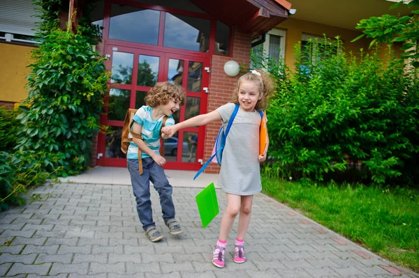 Мальчик и девочка идут в школу, взявшись за руки . — стоковое фото