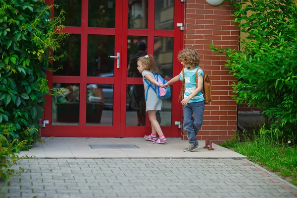 Ragazzo e ragazza vanno a scuola avendo unito le mani . — Foto Stock