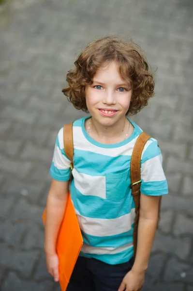 Ο παιδτύπος στέκεται στην αυλή του σχολείου και χαμογελά. — Φωτογραφία Αρχείου