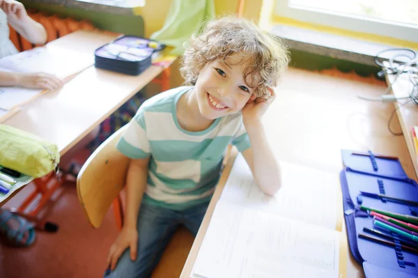 Die blondhaarige Schülerin sitzt in einer Klasse am Schreibtisch. — Stockfoto