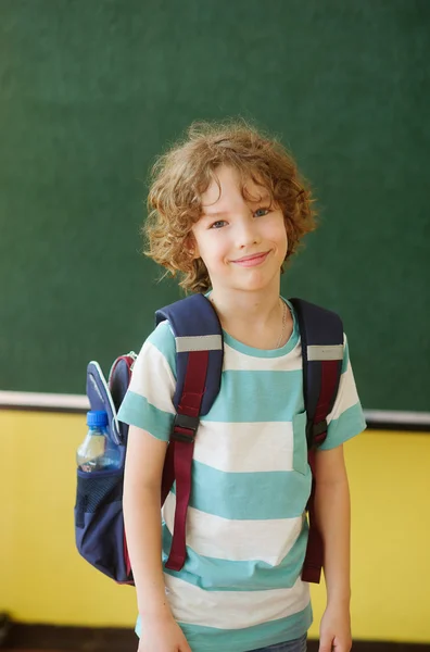 Grundschüler steht in der Klasse neben einer Tafel. — Stockfoto