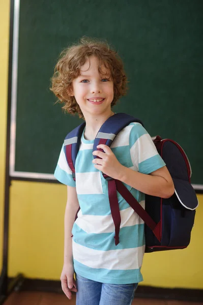 Lo scolaro di scuola elementare sta nella classe vicino a una asse . — Foto Stock